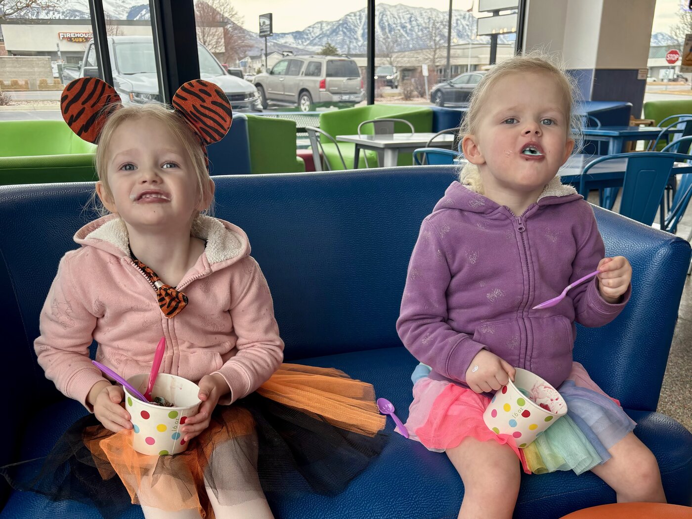 Two sisters enjoying froyo on the blue couch at American Fork