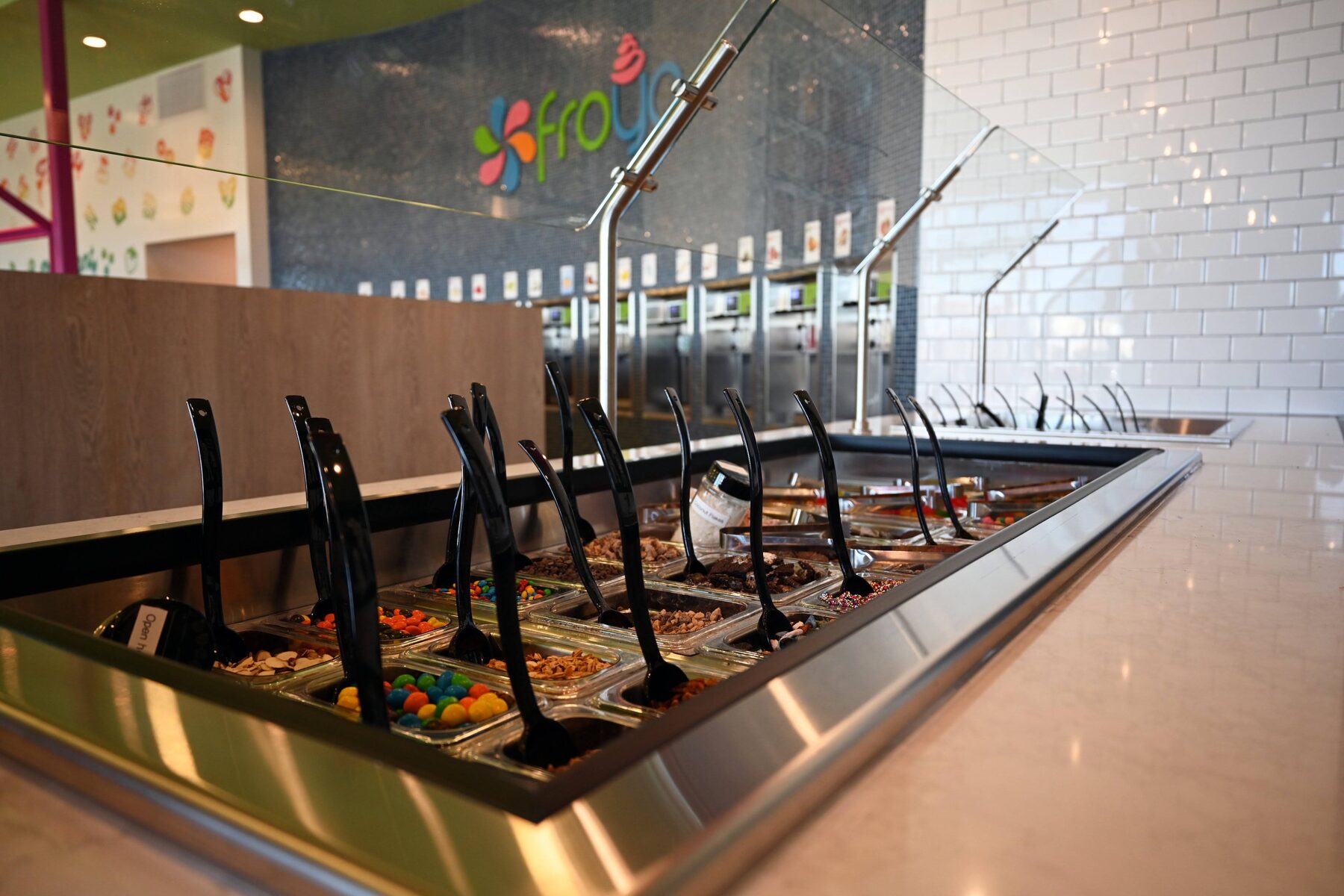 Inside our Froyo Spanish Fork shop with toppings bar, yogurt wall, and seating