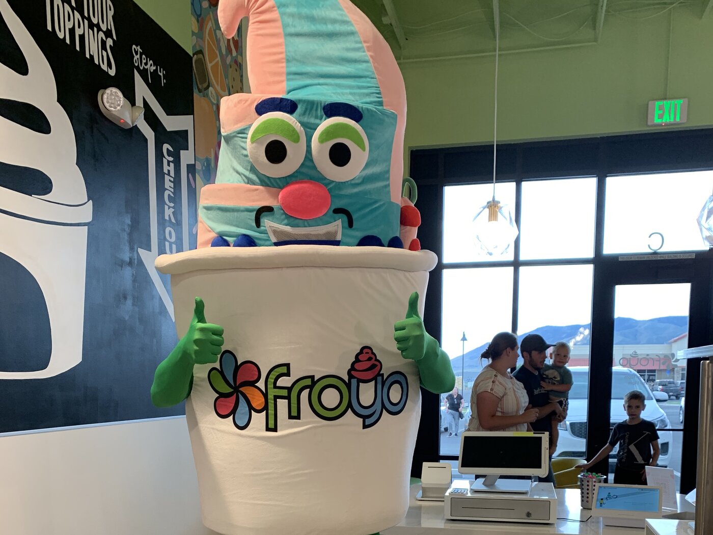 Froyo cup mascot in costume greeting customers at the Saratoga Springs counter
